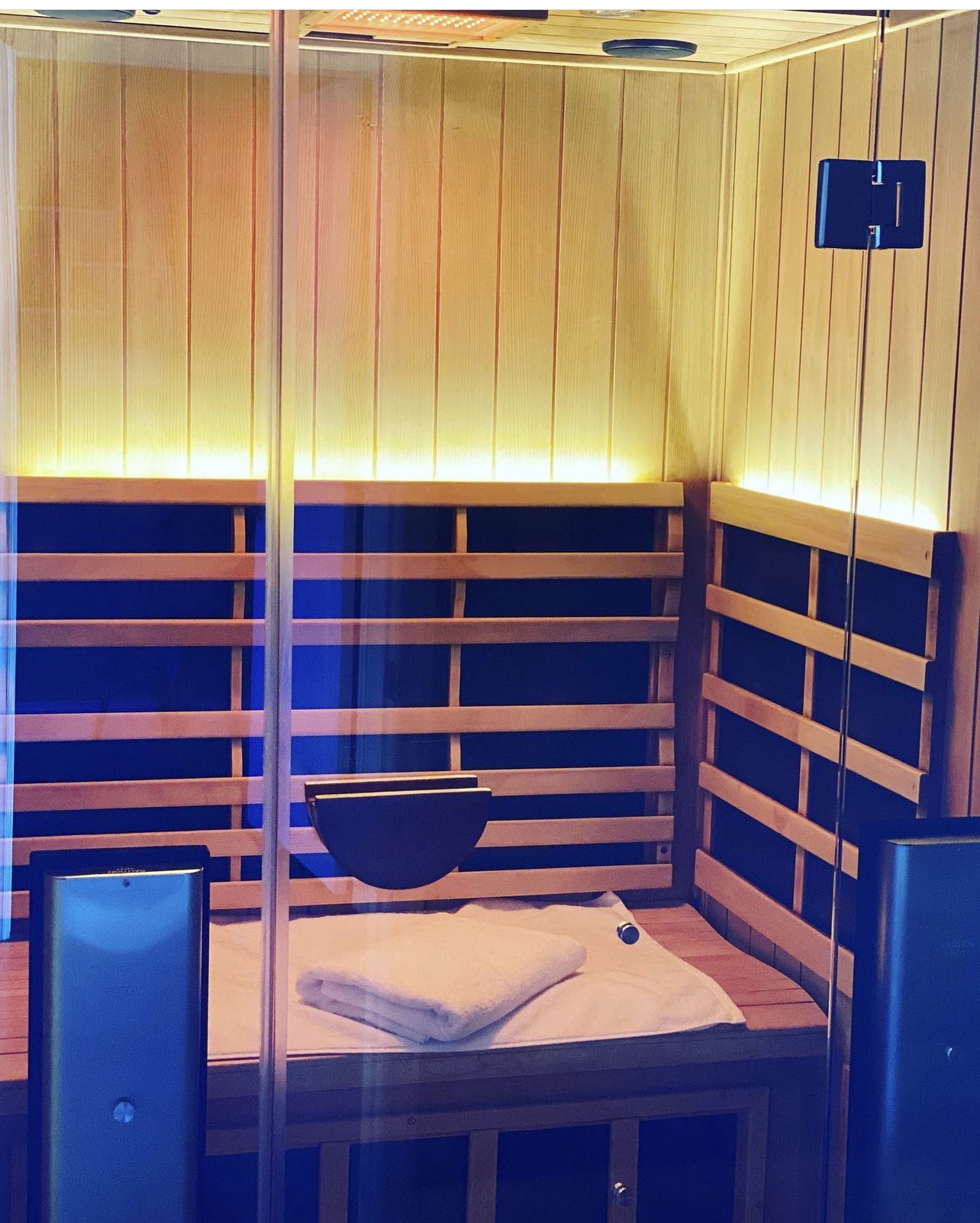 Private infrared sauna interior with warm wood and blue light panels
